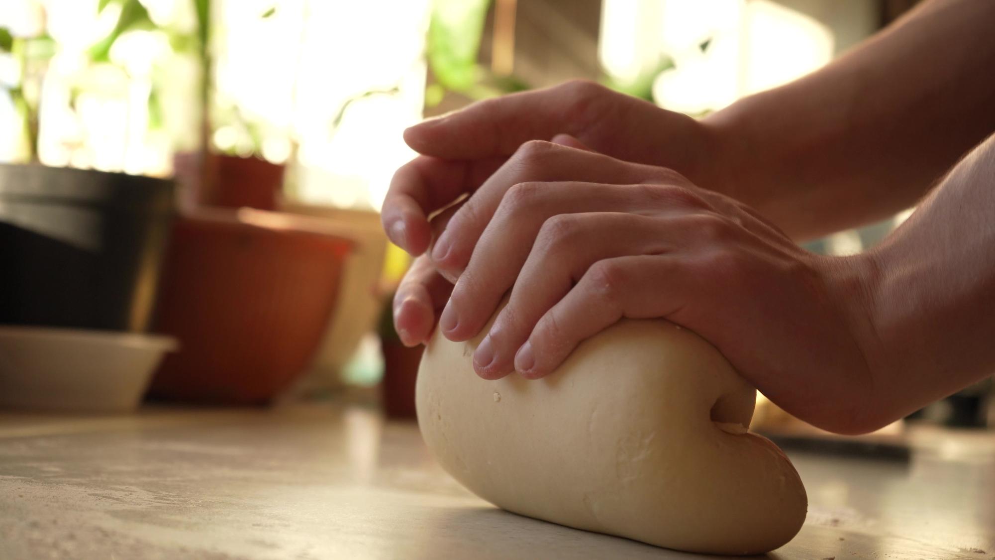 Close-up of hands kneading dough